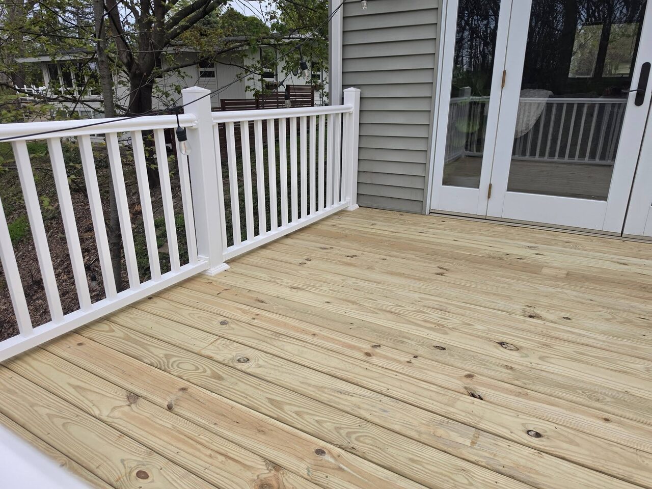 A freshly built backyard deck with new white railing by Young's Handyman on the southwest Michigan lakeshore