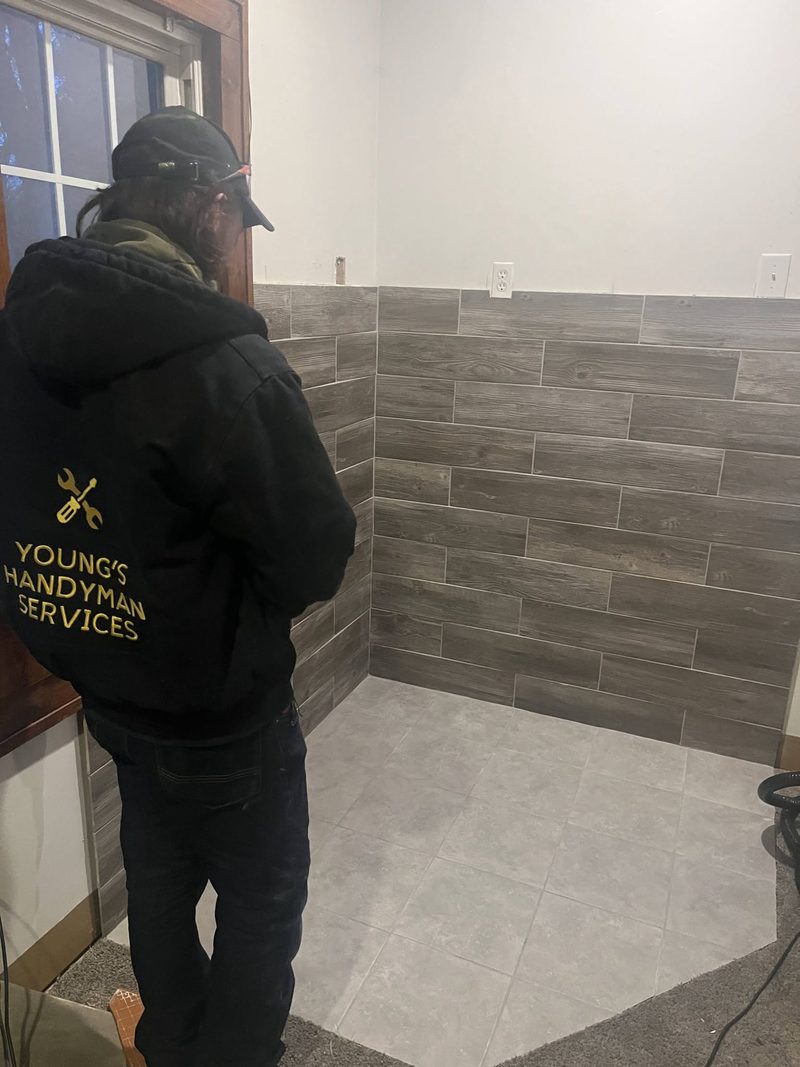 A Young's Handyman crew member finishing a bathroom tile job